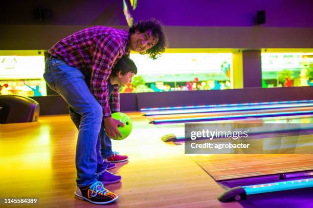 vater und sohn in der kegelbahn - family bowling stock-fotos und bilder