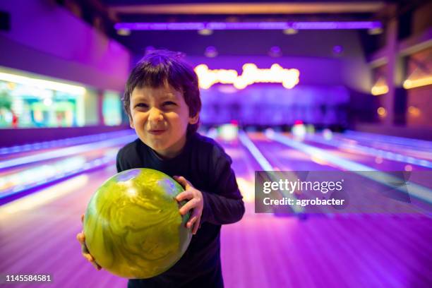 porträt nettes kind mit ball in bowlingclub - bowler hat stock-fotos und bilder