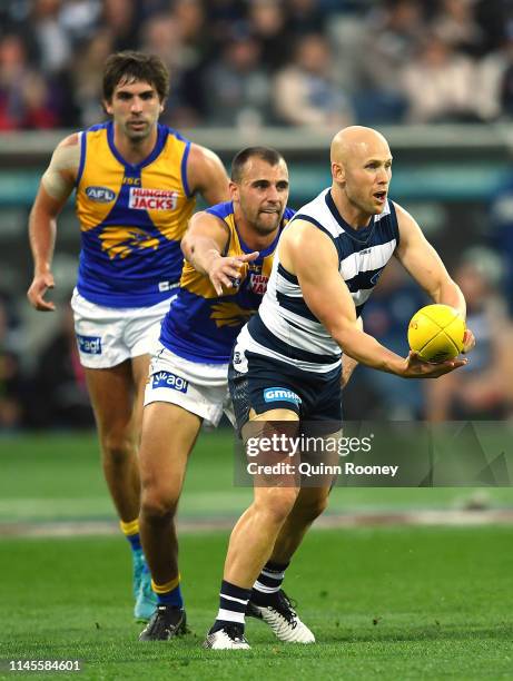 Gary Ablett of the Cats handballs whilst being tackled by Dom Sheed of the Eagles during the round 6 AFL match between Geelong and West Coast at...