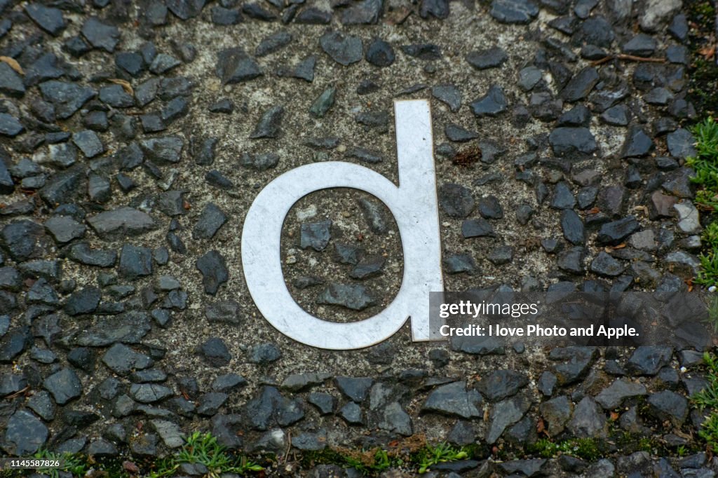 A small letter of the metal alphabet embedded in a road