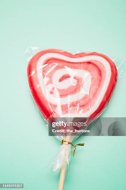 high angle view of lollipop in heart shape on turquoise background - food covered stock pictures, royalty-free photos & images