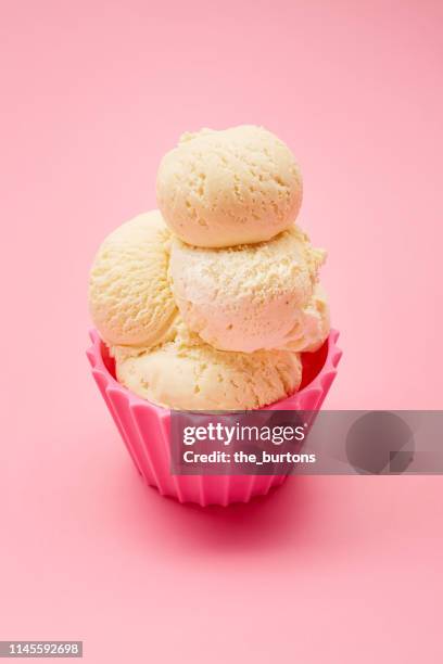 close-up of scoops of vanilla ice cream in a pink bowl - vanilleeis stock-fotos und bilder