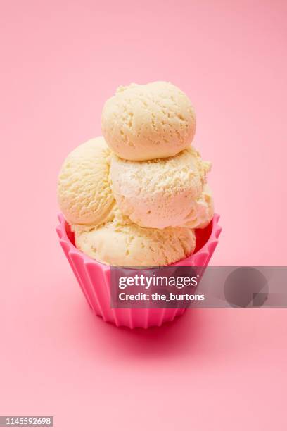 close-up of scoops of vanilla ice cream in a pink bowl - ice cream scoop stock-fotos und bilder