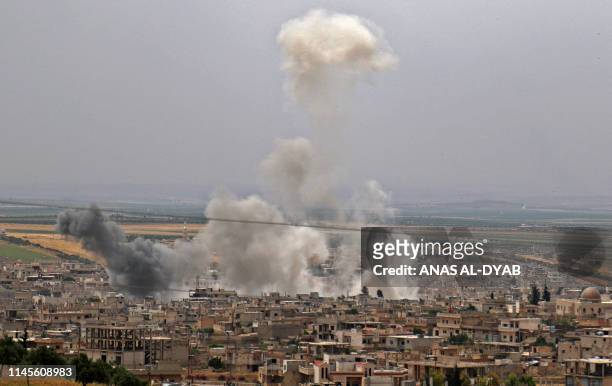 This picture taken on May 23, 2019 shows smoke plumes rising following reported Syrian government forces' bombardment on the town of Khan Sheikhun in...