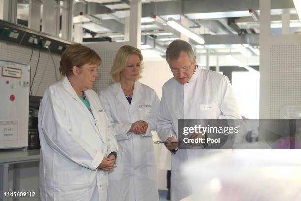 German Federal Chancellor Angela Merkel visits Centogene AG, seen here with the chairman of the board Arndt Rolfs and Mecklenburg-Western Pomerania's...