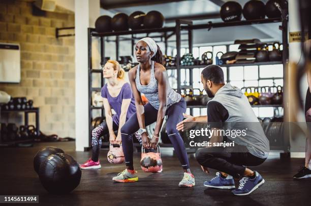 people exercising in a gym with medicine balls - personal trainer stock pictures, royalty-free photos & images