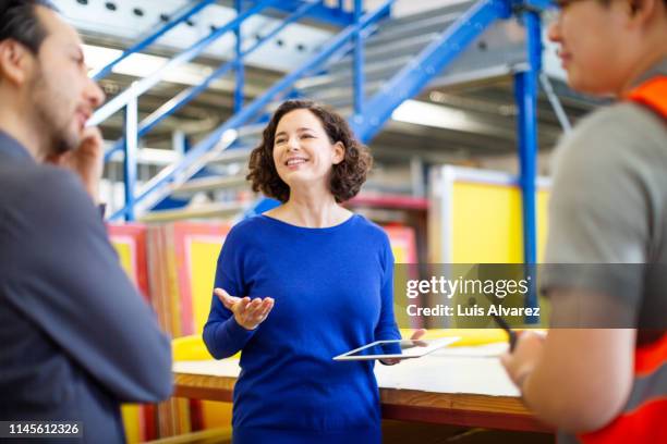 warehouse manager talking with workers - factory workteam stock-fotos und bilder