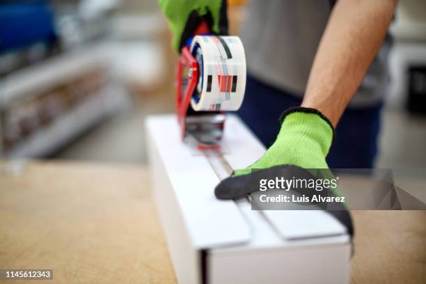 warehouse worker preparing a parcel for delivery - self closing stockfoto's en -beelden