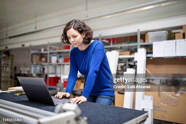 female warehouse manager working on laptop - table front view stock pictures, royalty-free photos & images