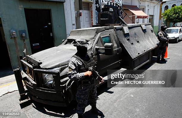 Mexican policemen stand guard next to an armoured car seized to alleged members of the Mexican drug cartel "Los Zetas" and presented to the press on...