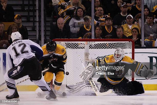 Simon Gagne of the Tampa Bay Lightning scores a first period goal past Johnny Boychuk and Tim Thomas of the Boston Bruins in Game Five of the Eastern...
