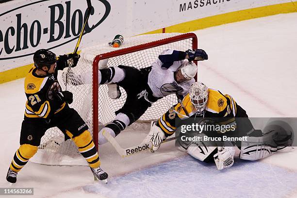 Andrew Ference of the Boston Bruins checks Steven Stamkos of the Tampa Bay Lightning over the top of Tim Thomas of the Boston Bruins and is called...