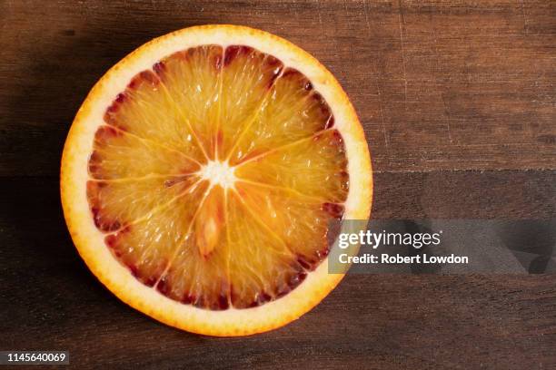 blood orange close up - bloedsinaasappel stockfoto's en -beelden