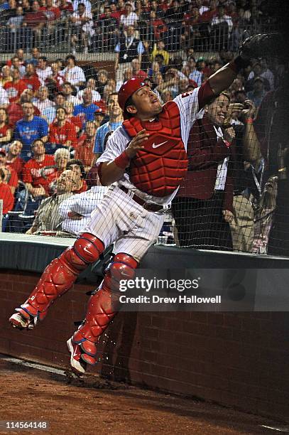 Carlos Ruiz of the Philadelphia Phillies jumps into the backstop to catch a foul ball during the game against the Cincinnati Reds at Citizens Bank...