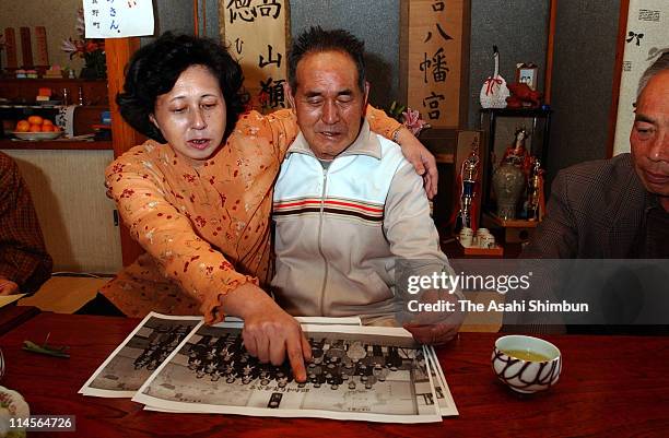 Hitomi Soga and her father Shigeru watch the photo taken at the graduation ceremony of her elementary school on October 22, 2002 in Mano, Niigata,...