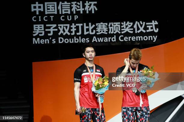 Marcus Fernaldi Gideon and Kevin Sanjaya Sukamuljo of Indonesia react during the awards ceremony after the Men's Doubles final match against Hiroyuki...