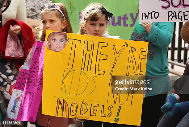 Demonstrators hold up signs in protest during the "Pull the Pin" national rally against child beauty pageants at State Parliament House on May 24,...