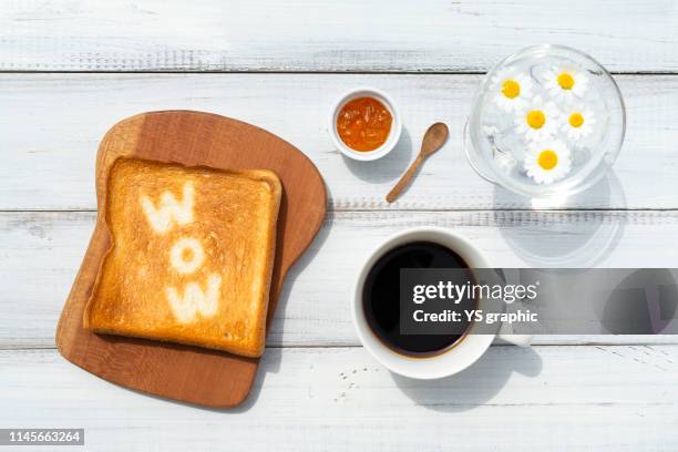 toast art "wow", breakfast of bread and marmalade and black coffee. - white bread stockfoto's en -beelden