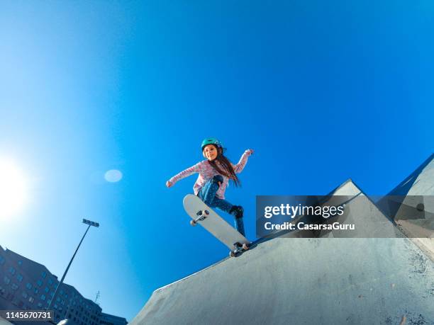 little girl standing on the edge of the skatepark ramp - skating helmet stock pictures, royalty-free photos & images