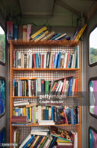 book library in old phone booth - telefonzelle stock-fotos und bilder