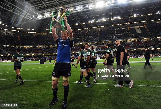 Leinster's Irish lock Leo Cullen holds the trophy as he celebrates after winning their Heineken Cup Final match against Northampton Saints at the...