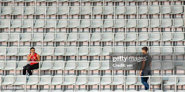 two people on a stadium before music event - early bird stock pictures, royalty-free photos & images