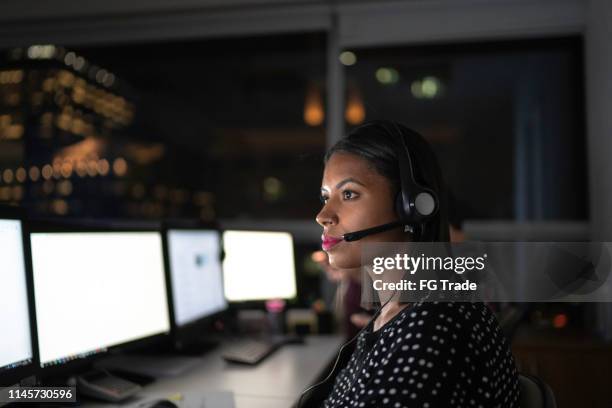 agente de servicio al cliente trabajando tarde - call center serious fotografías e imágenes de stock