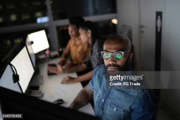 zakenman die laat in het bureau werkt - developer stockfoto's en -beelden