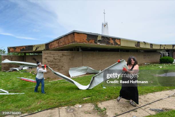 Noel Edmonds, left, and Berkley Silvey help remove debris from around Community Christian Church on May 23, 2019 in Jefferson City, Missouri. The two...