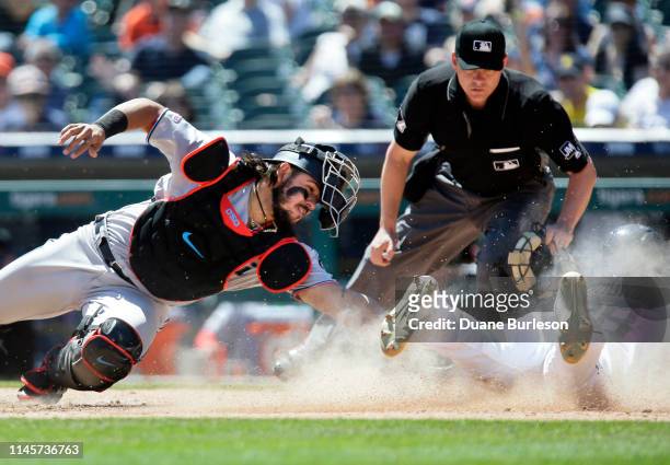 Niko Goodrum of the Detroit Tigers beats the tag from catcher Jorge Alfaro of the Miami Marlins to score on a sacrifice fly hit by Ronny Rodriguez...