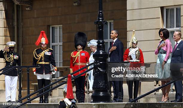 President Barack Obama puts his hand on his chest as the US national anthem is played as he stands beside Britain's Queen Elizabeth II, US First Lady...