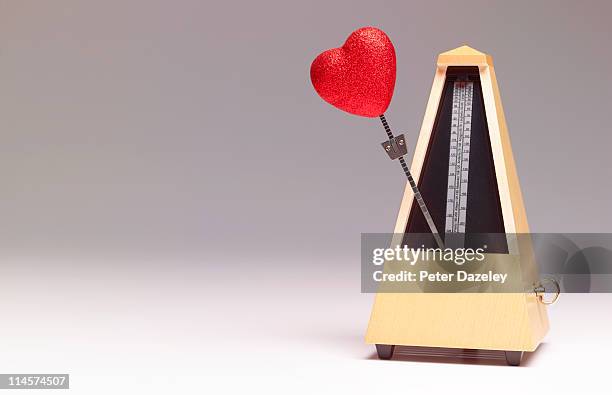 metronome with heart shape - biologische uhr stock-fotos und bilder