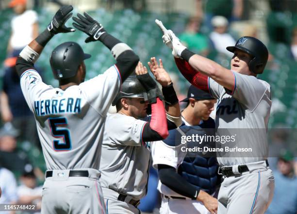 Garrett Cooper of the Miami Marlins, right, celebrates his grand slam against the Detroit Tigers with Rosell Herrera and Miguel Rojas during the...