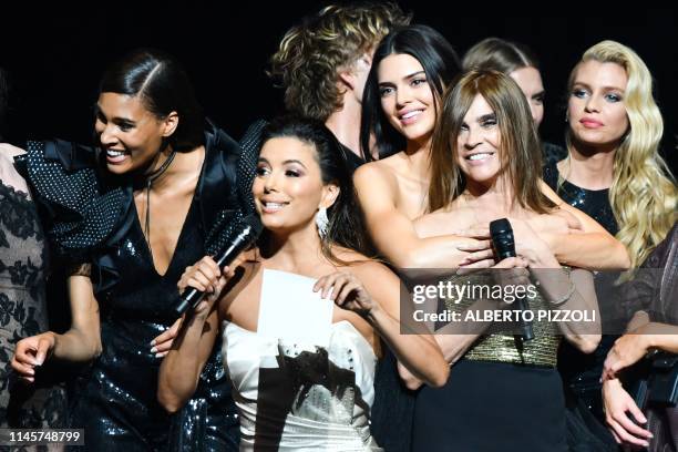 French designer and fashion editor Carine Roitfeld and US actress Eva Longoria conduct a auction on stage on May 23, 2019 with French model Cindy...