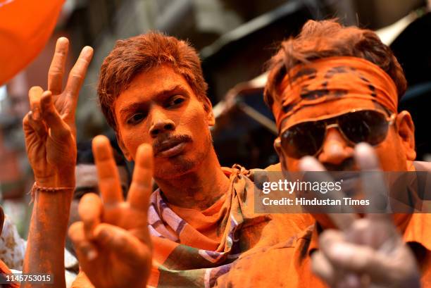 Bharatiya Janata Party supporters are smeared with saffron colour to celebrate the lead of the party in the Lok Sabha election results, at BJP...