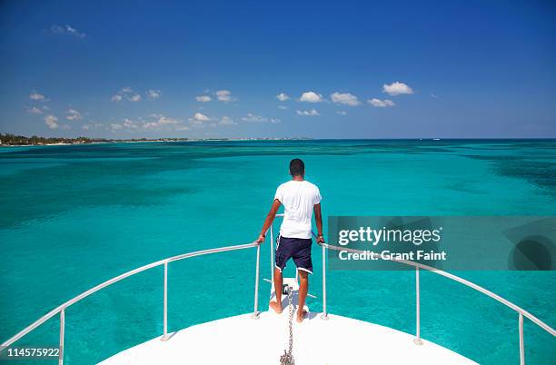 man a front of boat. - nassau bahamas stock pictures, royalty-free photos & images