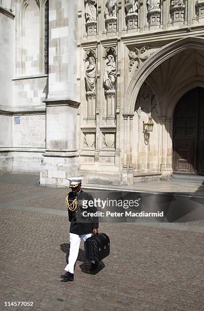 Military officer carries a bag known as the 'football,' which carries nuclear launch codes from Westminster Abbey as President Barack Obama and first...
