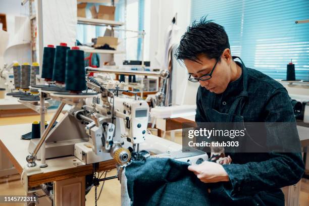 mitteler erwachsener schneider, der an einer nähmaschine in seinem designstudio arbeitet - präfektur okayama stock-fotos und bilder