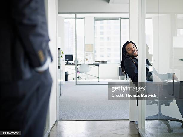 businessman sitting in discussion with coworker - dreadlocks stockfoto's en -beelden