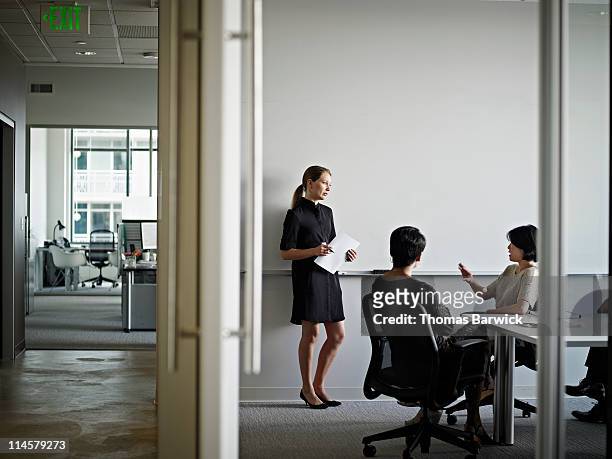 businesswoman in discussion with coworkers - incidental people stock pictures, royalty-free photos & images