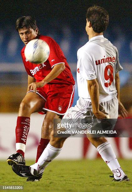 Emilio Valdes , of Mexico's Toluca team, kicks the ball in front of Fernando Diniz , of the Brazilian team Fluminese, during a friendly match to...