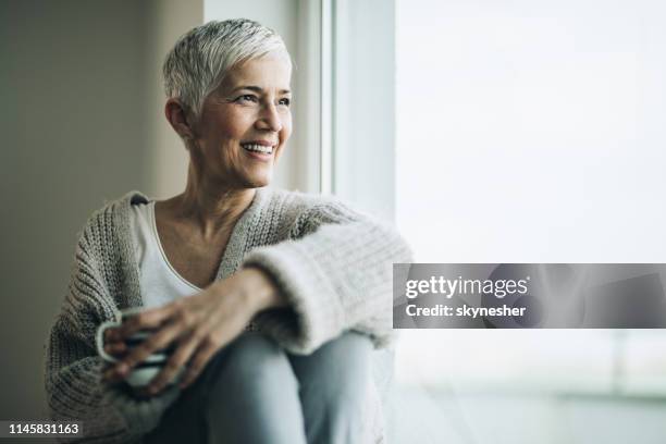mulher madura feliz com o copo de café que relaxa pelo indicador. - cabelo-curto-estilo-de-cabelo - fotografias e filmes do acervo
