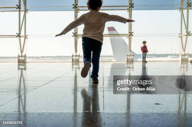 mutter spielt mit ihren kindern am flughafen - kind flugzeug stock-fotos und bilder