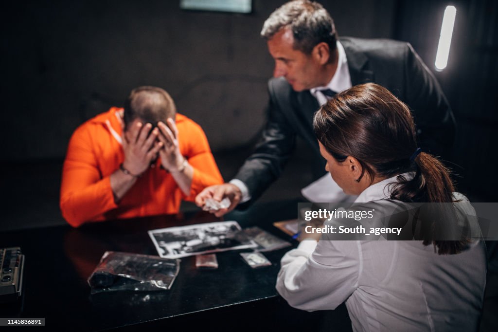 Detectives And Prisoner In Interrogation Room High-Res Stock Photo ...