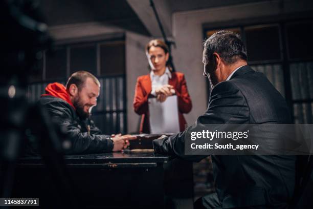 two detectives interrogating a prisoner - victim advocate stock pictures, royalty-free photos & images