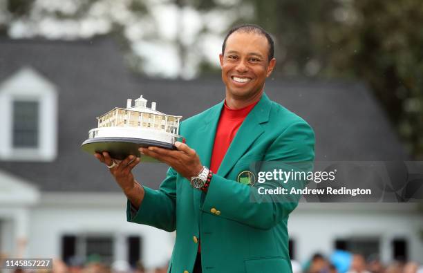 Tiger Woods of the United States celebrates with the Masters Trophy during the Green Jacket Ceremony after winning the Masters at Augusta National...