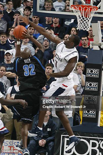 University of Connecticut center Emeka Okafor blocks a shot by Georgetown's Gerald Riley during a game, Storrs, Connecticut, June 25, 2002.