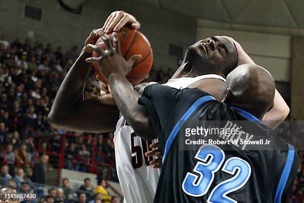 University of Connecticut center Emeka Okafor and Georgetown's Gerald Riley wrestle for a rebound during a game, Storrs, Connecticut, June 25, 2002.