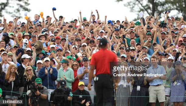 Patrons applaud Tiger Woods of the United States as he leaves the 18th green after winning the Masters at Augusta National Golf Club on April 14,...