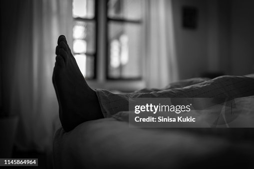 Man's feet in bed
